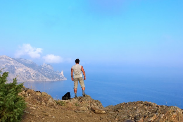 Traveler looks at the beautiful seascape from the mountain top