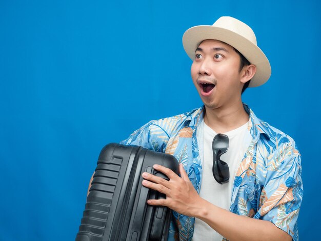 Traveler man hold luggage feels excited looking at copy space