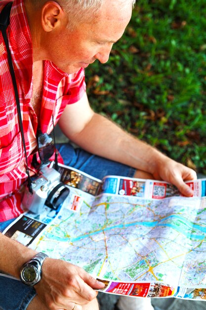 Foto l'uomo viaggiatore si trova nel centro della città e studia una mappa di budapest.