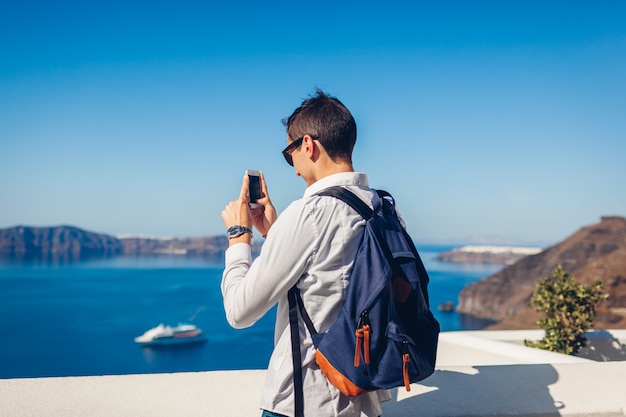 彼のスマートフォンで写真を撮る旅行者男