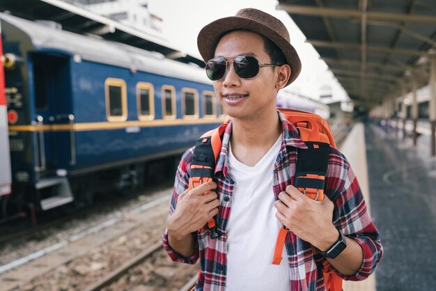 駅でバッグパックを持つ旅行者の男