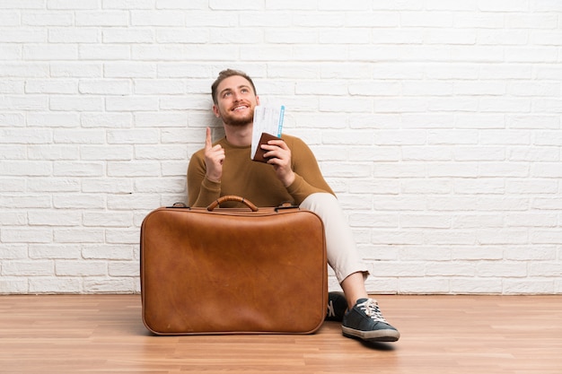 Traveler man with suitcase and boarding pass pointing up a great idea