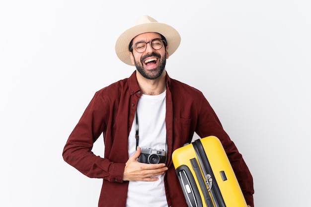 Photo traveler man with suitcase over isolated wall