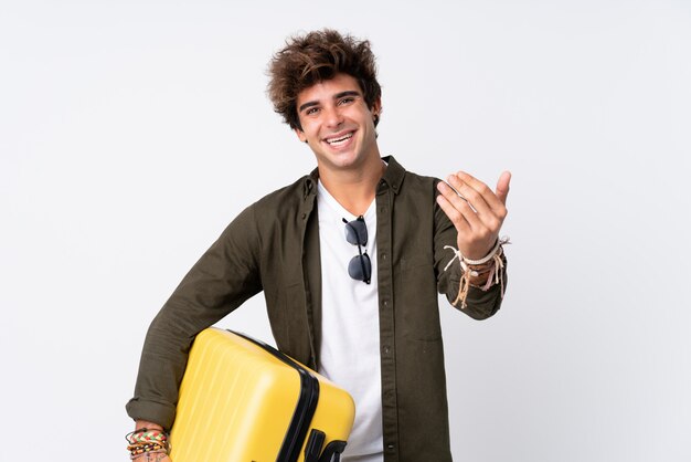 Traveler man with suitcase over isolated wall