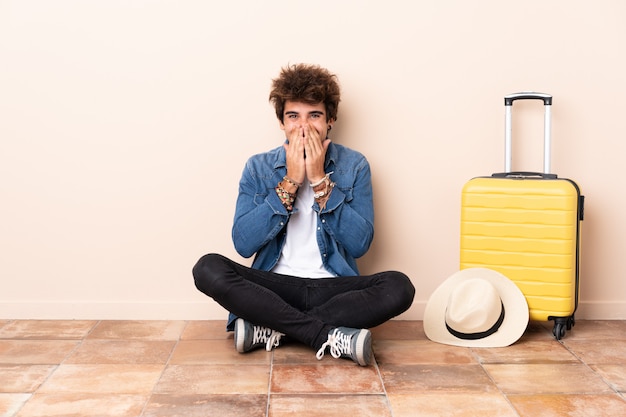 Traveler man with suitcase over isolated wall