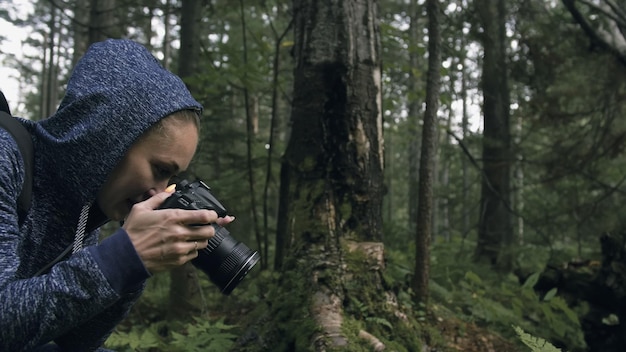 Photo traveler photographing scenic view in forest one caucasian woman shooting nice magic look girl take photo video on dslr mirrorless camera professional photographer travel with backpack outdoor