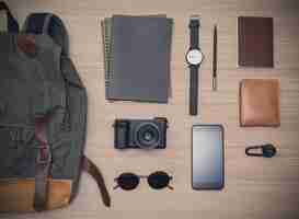Photo traveler's accessories with passport, books of travel plan, wallet, camera, campass, backpack and mobile phone on oak wooden table