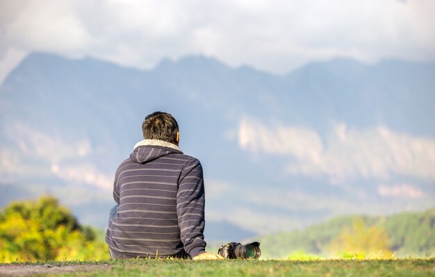 Traveler sit with his camera on beautiful view point