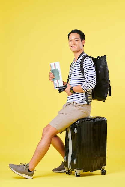 Traveler sitting on suitcase