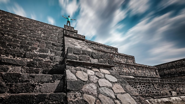 Un viaggiatore in piedi sulla cima della piramide di teotihuacan