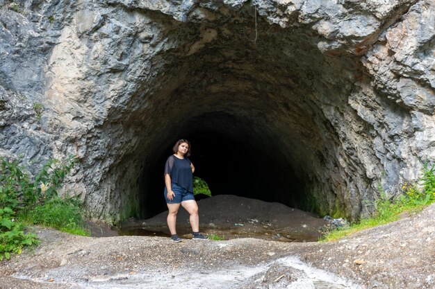 Photo a traveler stands at the entrance to a large cave