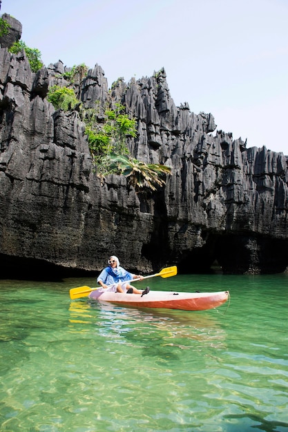 タイの旅行者タイの女性が海の海の旅で地元の旅行ツアーのカヌーボートを漕ぐサトゥーンタイのラグーのパックバラにあるムーコペトラ国立公園のカオヤイ石島とプラサートヒンパンヨッドを訪問