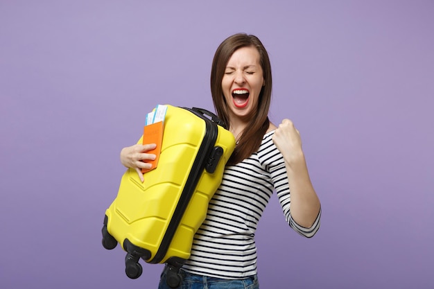 Traveler tourist woman girl in casual striped clothes posing isolated on violet purple background studio portrait. Passenger traveling abroad to travel on weekends getaway. Air flight journey concept.