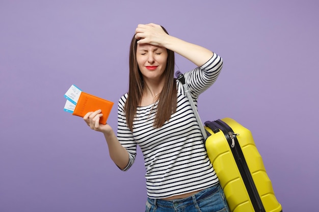 Traveler tourist woman girl in casual striped clothes posing isolated on violet purple background studio portrait. Passenger traveling abroad to travel on weekends getaway. Air flight journey concept.