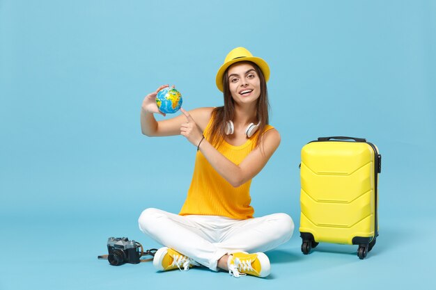 Traveler tourist woman in yellow casual clothes, hat with suitcase photo camera on blue