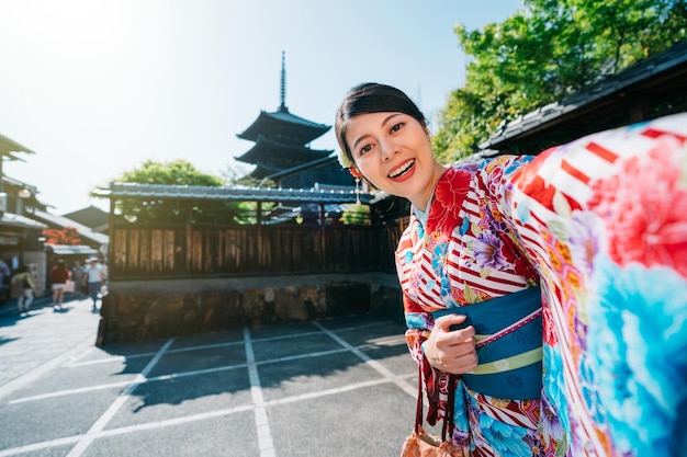 기모노를 입고 교토의 유명한 탑과 셀카를 찍는 여행자. 여행자는 전통적인 일본 라이프스타일 개념을 경험합니다. 아름다운 여자는 자기 초상화를 찍는 것을 좋아합니다.