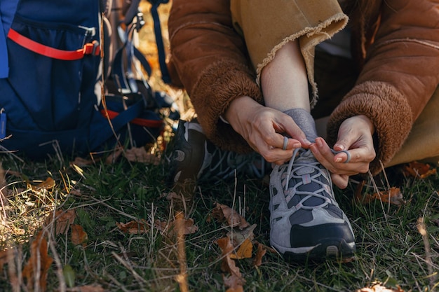 Traveler tying shoelaces on trekking boots in nature