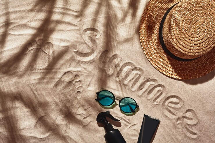 Traveler vacation accessories are laid out on a white beach sand flat lay top view