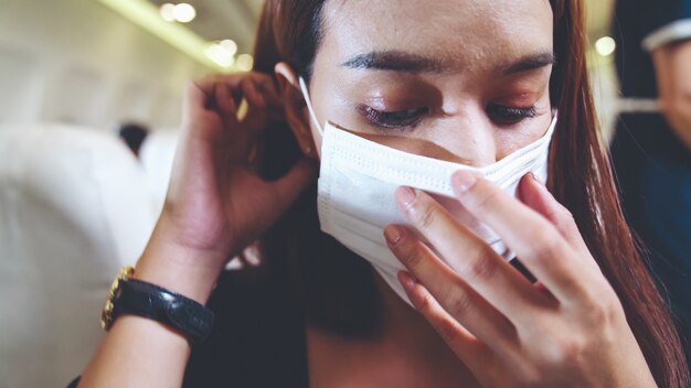 Traveler wearing face mask while traveling on a commercial airplane