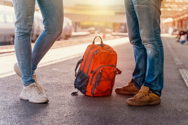 Traveler with backpack waiting for a train at trainstation\
travel concept