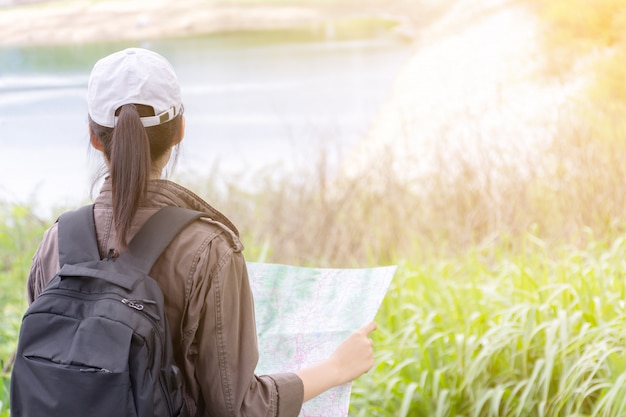 Viaggiatore con mappa e zaino in mattinata