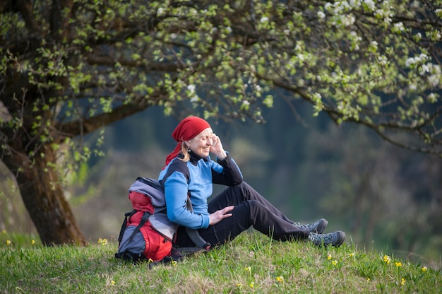 Traveler woman with a backpack near blooming tree