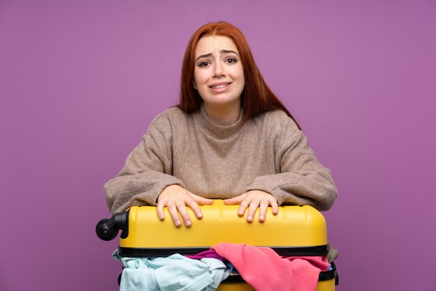 Foto donna viaggiatore con una valigia piena di vestiti