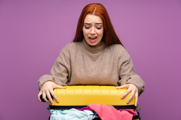 Foto donna viaggiatore con una valigia piena di vestiti