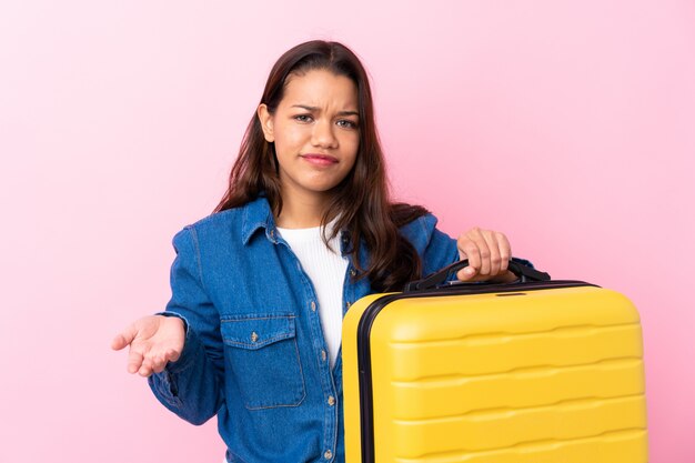 Traveler woman with suitcase over isolated wall