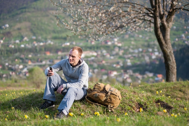 Traveler young man with backpack on hill