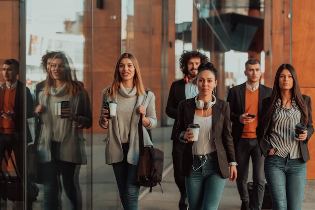 I viaggiatori d'affari team di colleghi che camminano e parlano nelle moderne strade urbane della città. persone fuori ufficio in pausa. foto di alta qualità