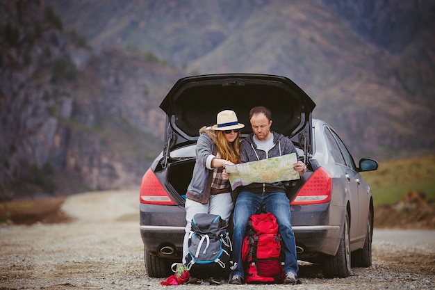 Travelers by car in the mountains in spring see the map