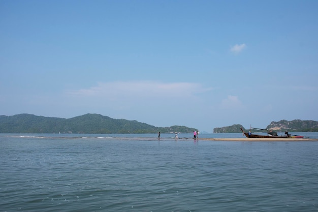 태국 사툰(Satun Thailand) 란구(La ngu) 시의 팍 바라(Pak Bara)에 있는 램 태 판(Laem Tae Pan)에 있는 탈레 왁 산 랑 망콘(Thale Waek San Lang Mangkorn) 또는 분리된 바다(Separated Sea)를 방문하기 위해 현지 목조 롱테일 보트를 타고 여행하는 태국 사람들