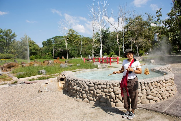 旅行者タイの女性が訪れ、タイのチェンマイ県チェンマイ市のメーオン地区にあるサンカンペーン温泉温泉のプールミネラルお湯で沸騰した卵を調理します