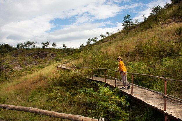 태국 여성 여행자들은 태국 나콘나욕 지방 사리카에 있는 카오론 어드벤처 포인트(Khao Lon Adventure Point)의 바위산 숲에서 휴식을 취하고 트레킹 코스를 하이킹하며 사진을 찍습니다.