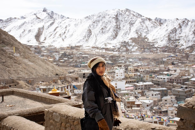 태국 여성 여행자들은 겨울철에 잠무(Jammu)와 카슈미르 인도(Kashmir India)에 있는 레 스톡 궁전(Leh Stok Palace)의 관점에서 레 라다크 마을(Leh Ladakh Village)의 풍경을 방문하고 사진을 찍습니다.