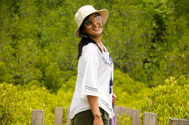 Photo travelers thai women portrait for take photo on wooden bridge for travel and visit golden mangrove field thai name tung prong thong forest local pak nam prasae town in rayong thailand