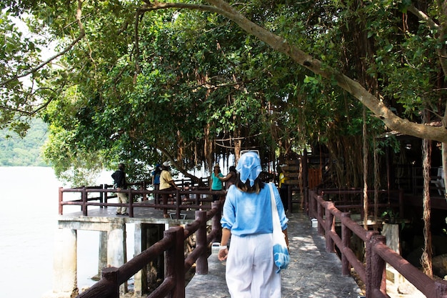 Travelers thai women travel visit and walk on stone bridge of time travel journey zone in sea ocean of Mu Ko Petra National Park in Pak Bara village at La ngu city on April 11 2022 in Satun Thailand