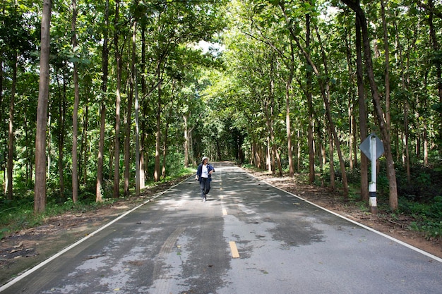 Travelers thai women walking posing and portrait for take photo on road in forest in Wat Tham Klong phen forest temple at Phu Phan mountain in Nong Bua Lamphu Thailand