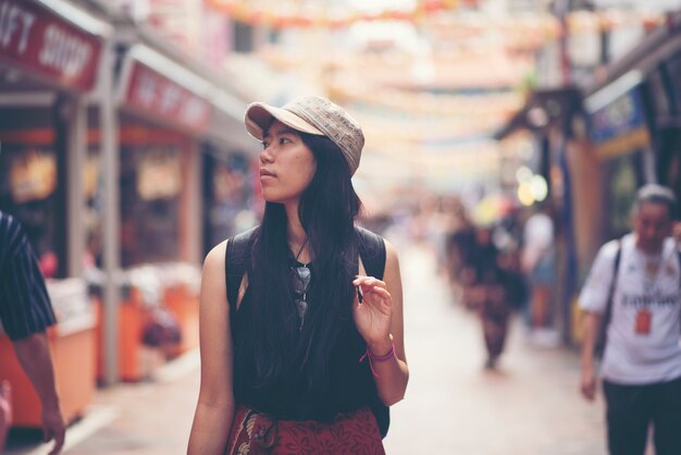 中国の町、シンガポールで歩いているトラベラー女性のバックパッカー