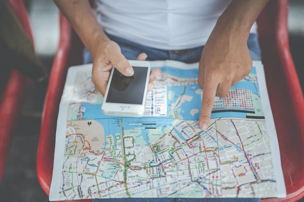 Travelers young woman with backpack looking hold a map at the train station. Tourism day.