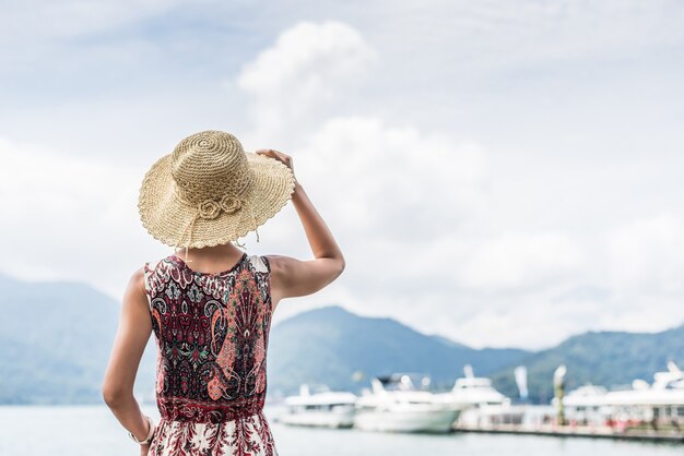 Viaggiare donna asiatica con cappello in piedi al sun moon lake, taiwan