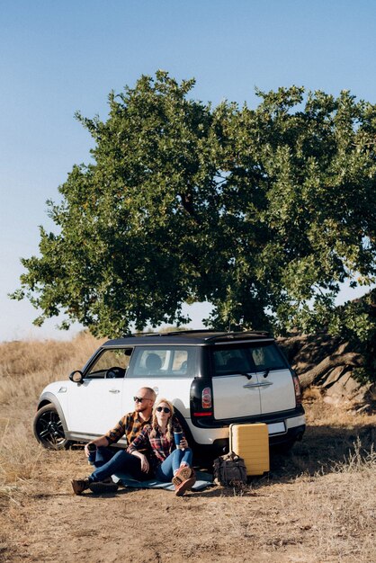 Traveling by car of a young couple of a guy and a girl in plaid shirts