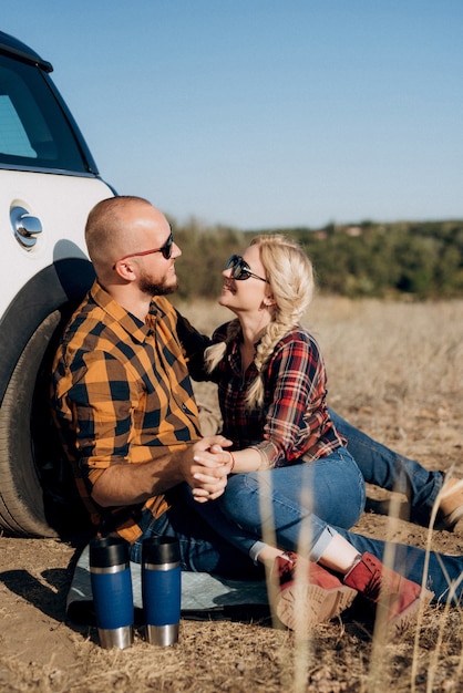 Traveling by car of a young couple of a guy and a girl in plaid shirts