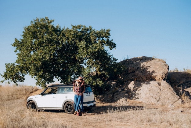 Traveling by car of a young couple of a guy and a girl in plaid shirts