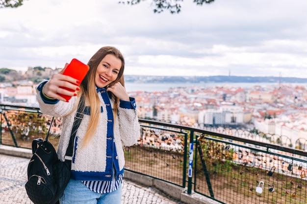 Photo traveling by portugal young traveling woman taking selfie in old town lisbon