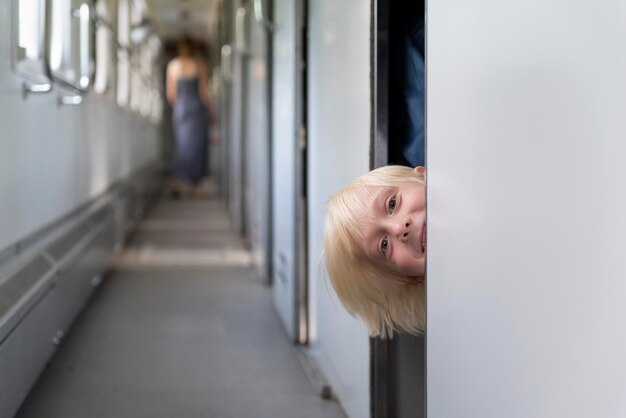 Traveling by the train Blond boy looks out of the compartment and laughs