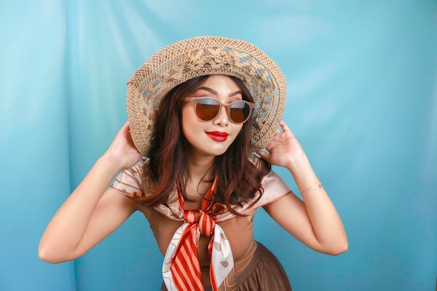 Traveling concept of a young Asian happy woman isolated by a blue background