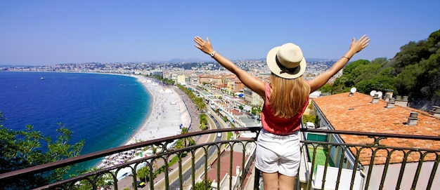 Traveling in france panoramic view of beautiful girl with open\
arms on nice city french riviera