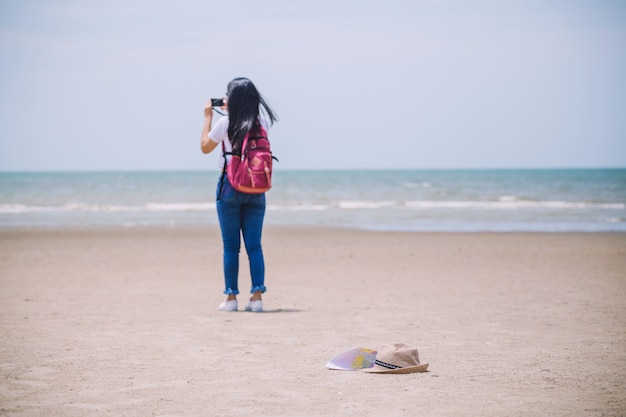 Traveling people concept Young happy asian gril at the beach